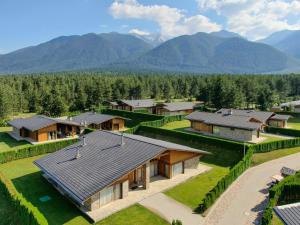 an aerial view of a house with mountains in the background at Luxury Chalets Pirin Golf & Country Club in Bansko