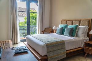a bedroom with a large bed and a large window at The Merchant in Galle