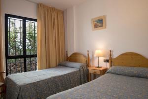A bed or beds in a room at Apartamentos Perla Marina
