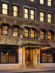 een groot bakstenen gebouw met verlichting in de ramen bij The Marlton Hotel in New York