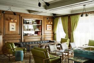 a waiting room with green chairs and tables at The Marlton Hotel in New York