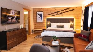 um quarto com uma cama grande e um sofá em Wunderstay Alpine 3 Chic Studio Central Location em Klosters Serneus