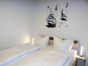 ein Schlafzimmer mit einem Bett mit einem Segelboot an der Wand in der Unterkunft Speicher Residenz Barth E4 App 4 in Barth