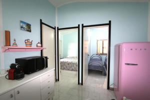 Habitación con nevera rosa y dormitorio. en Casa Josto en Maladroscia