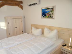 a white bed with white pillows in a bedroom at Speicher Residenz Barth E3 App 11 in Barth