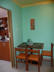 a dining room table with two chairs and a table at Panoráma Panzió in Matrafured