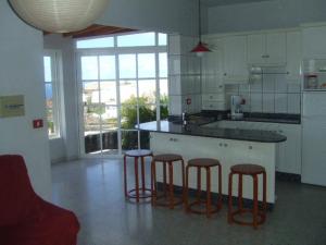 una cocina con 3 taburetes y una barra en Bungalows & Apartamentos Morani, en Puerto Naos