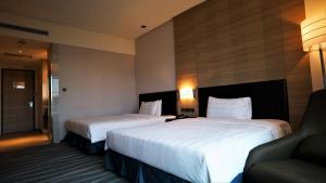 a hotel room with two beds and two lamps at City Suites - Kaohsiung Chenai in Kaohsiung