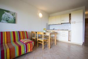 cocina con mesa, sofá, mesa y sillas en Residence de Tourisme Marina Corsa, en Ghisonaccia