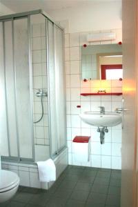 a bathroom with a sink and a shower and a toilet at ZirkelsteinResort gGmbH in Schöna +77 photos