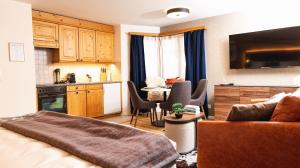 a bedroom with a bed and a kitchen with a table at Wunderstay Alpine 16 Chic Studio Central Location in Klosters Serneus