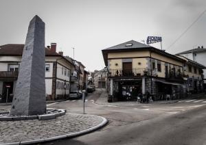 uma rua com um edifício e um poste na esquina em Hostal Rural El Caño by Vivere Stays em Alpedrete