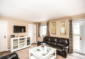 a living room with a couch and a tv at Summerside Cottage in Gullane