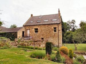 an old stone house with solar panels on the roof at Dilston Mill in Hexham