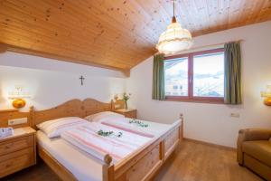 a bedroom with a large bed and a wooden ceiling at Binterhof in Castelrotto