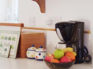 a bowl of fruit on a counter next to a coffee maker at Dilston Mill in Hexham