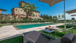 a swimming pool in front of a building with a house at La Torre di Testa Lepre in Greve in Chianti