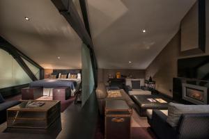 een kamer met 2 bedden, een bank en een open haard bij Malmaison Belfast in Belfast