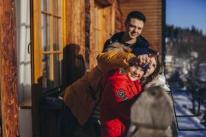 un hombre está ayudando a una mujer con su pelo en Pensjonat Puchaczówka en Sienna