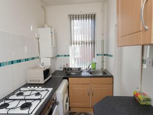 a small kitchen with a stove and a microwave at Eastpark Residence in Leeds