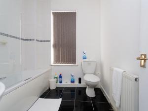 La salle de bains est pourvue de toilettes, d'une baignoire et d'un lavabo. dans l'établissement Eastpark Residence, à Leeds