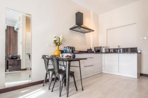 a kitchen with a table and chairs in a room at Glam Hotel Nairobi - Near Westgate Mall, Westlands in Nairobi