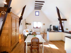 Le Gîte bleu في Willgottheim: مطبخ وغرفة معيشة مع طاولة وأريكة