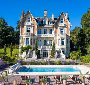 昂热Le Château des Forges的一座大房子,前面设有一个游泳池