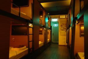 Habitación con 2 literas y puerta verde en Chic Capsule Otel, en Singapur