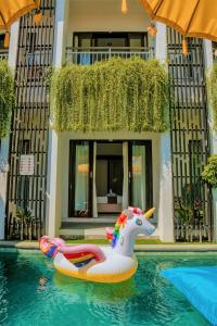 a unicorn float in a swimming pool at a resort at Bahana Guest House in Kuta