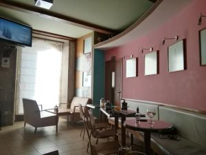 PICO SACRO I HOSTAL-PENSION Santiago de Compostela في سانتياغو دي كومبوستيلا: غرفة طعام مع طاولات وكراسي وتلفزيون