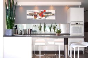 eine Küche mit einer Theke mit Hockern drum herum in der Unterkunft LUXUS Apartment mit Klimaanlage in Costa Calma