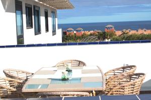 einen Tisch und Stühle auf einem Balkon mit Meerblick in der Unterkunft LUXUS Apartment mit Klimaanlage in Costa Calma