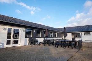 斯凯拜克Feriehuset Brøns的大楼前带长椅和遮阳伞的天井