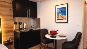 a kitchen with a small table and a sink at Wunderstay Alpine 403 Centric Studio Balcony/View in Davos