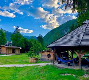 
a small hut with a wooden roof and wooden benches at Adrenaline Check Camping in Bovec
