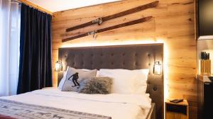 a bedroom with a large bed with a wooden wall at Wunderstay Alpine 403 Centric Studio Balcony/View in Davos