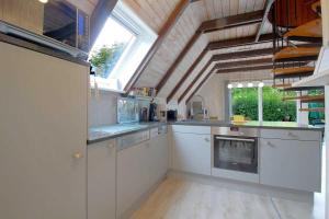 una grande cucina con armadi bianchi e una finestra di SE Robbenplate 19 a Dorum-Neufeld