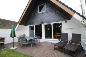 un patio con tavolo e sedie su un ponte di SE Robbenplate 19 a Dorum-Neufeld