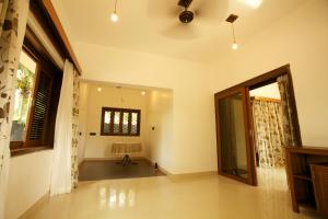 an empty living room with a ceiling fan at Dunhill Beach Resort in Agonda