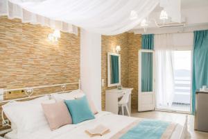 a bedroom with a white bed and a brick wall at Kafieris View in Firostefani