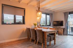 a dining room with a table and chairs at Stijlvol ingerichte bungalow in Baarland in Baarland