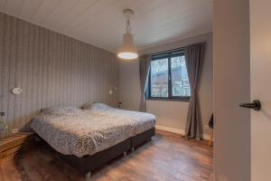 a bedroom with a bed and a window at Stijlvol ingerichte bungalow in Baarland in Baarland +32 photos