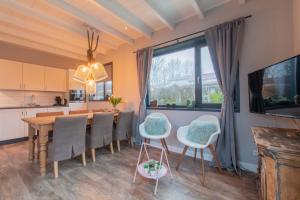cocina y comedor con mesa y sillas en Stijlvol ingerichte bungalow in Baarland, en Baarland