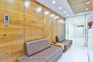two brown chairs in a room with a wooden wall at Hotel Nice RAILWAY STATION in Vadodara
