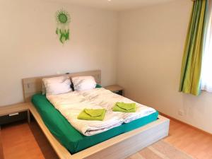 una piccola camera da letto con un letto con cuscini gialli di Haus Falke a Saas-Grund