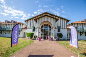 un bâtiment avec deux drapeaux devant lui dans l'établissement Olydea la Chalosse - Cassen, à Cassen