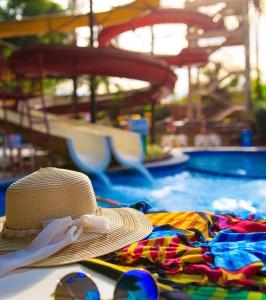 um chapéu de palha sentado numa toalha ao lado de uma piscina em Hotel Golden Dolphin com café da manhã! Piscinas 24h em Caldas Novas