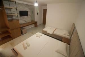 a small room with two beds and a tv at Hotel Four Islands in Ksamil