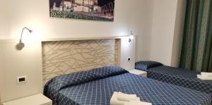 Habitación de hotel con 2 camas con sábanas azules en Sun Moon, en Roma
